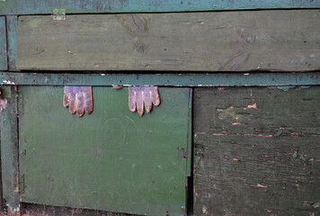 Luvas presas em uma arma&ccedil;&atilde;o de madeira