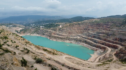 Fototapeta na wymiar A turquoise heart-like lake in a former quarry near Sevastopol