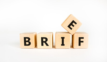 Brief symbol. The concept word 'brief' on wooden cubes on a beautiful white table, white background. Business and brief concept. Copy space.