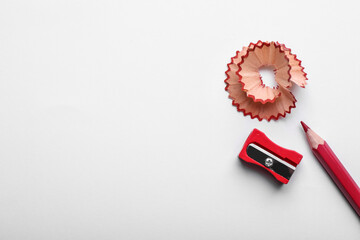 Red pencil, wooden shaving and sharpener on white background, top view - Powered by Adobe