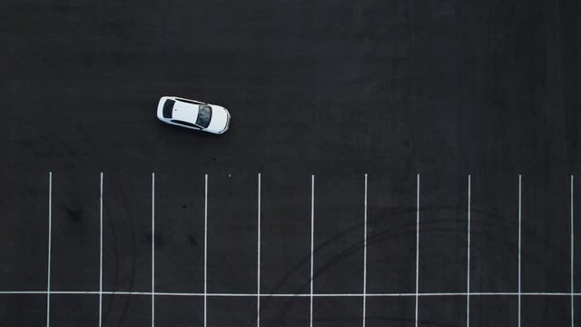 Aerial view of a white car parking incorrectly.