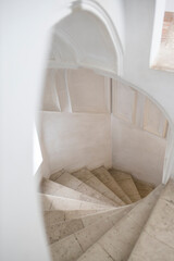 Fototapeta na wymiar White spiral staircase leading to the first floor of the church