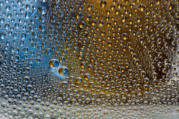 Golden-blue drops of water are located on a silver-golden-blue background. Abstract fantasy. 3D render.