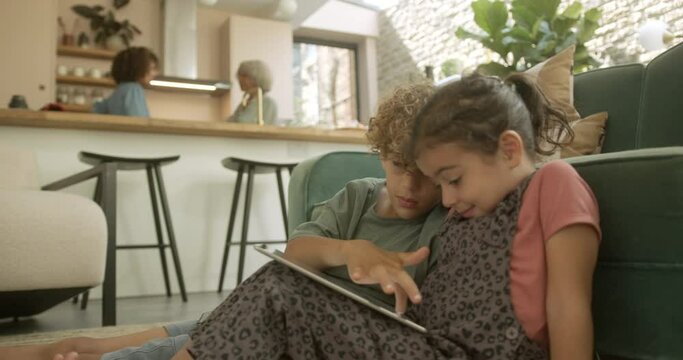 Mixed race brother and sister playing together on digital tablet