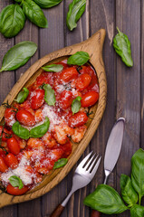 Gnocchi with tomatoes, red sauce, cheese and basil leaves