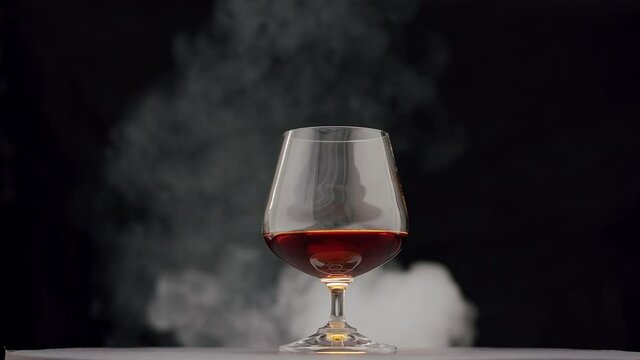 strong alcoholic drink Whiskey, Brandy, Cognac in glass with smoke from cigar