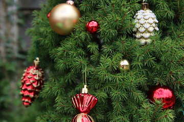 Close up photo of beautiful fir tree decorated with different types of Christmas balls and toys. Christmas celebration. 