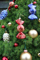 Close up photo of beautiful fir tree decorated with different types of Christmas balls and toys. Christmas celebration. 
