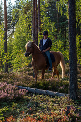 Man horseback riding in forest