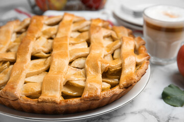 Delicious traditional apple pie on white marble table, closeup