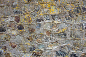 Colorful stone wall with protruding mortar pointing. Full frame background