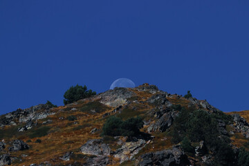 The moon hides in the Pyrenees mountains