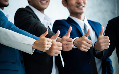 Teamwork of businessman thump up. Group of smiling young multi ethnic business people enjoying and showing gesture cool thumbs up. Team work, corporate, success concept.