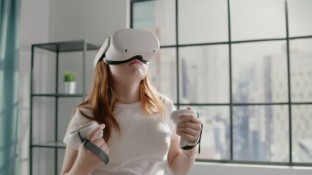 Girl in virtual reality glasses looks around catching things