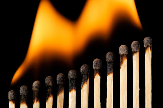 Burning matches make a growing line, all matchsticks on fire. Danger, ruination, problems spread and become bigger.