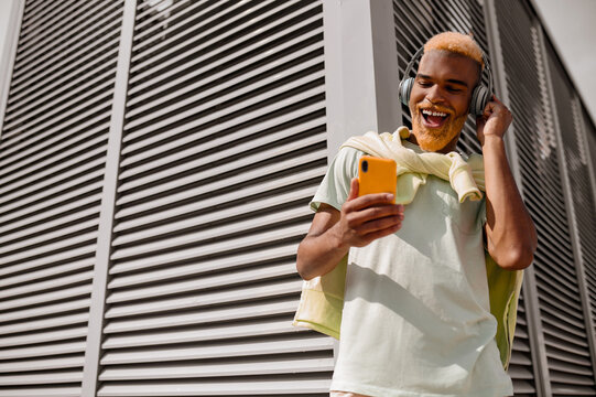 A dark-skinned bearded young man in headphones
