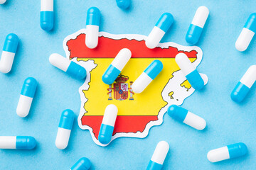 Flag of Spain with many capsules on top symbolising poor health condition of citizens. Medical situation in the country