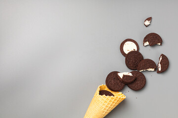 Ice cream cone with chocolate chip cookies with filling on gray background