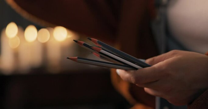 Close-up of the hand of a woman artist draughtswoman holding pencils natempered sharp, ready to work, tools for creating beautiful masterpieces, sketches, drawings, girl chooses one of utensils