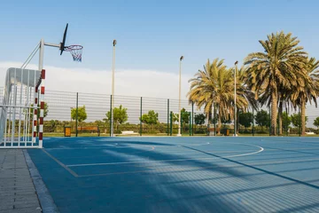 Foto op Canvas Side view Bright blue soccer and basketball court outside for children sports and recreation. © KingmaPhotos