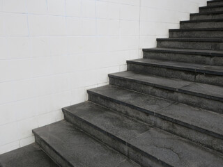 black stone stairs near a white tiled wall