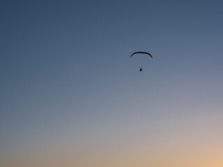 Nice sunset with motor paraglider flying in beautiful sky