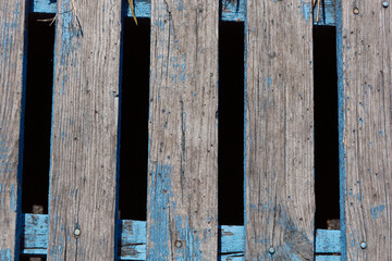 Blue painted wooden boards. Old blue wood background with peeling paint. Peeling paint on wooden slats.
