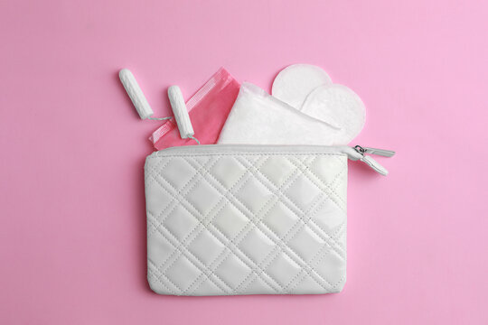 Bag with menstrual pads, tampons and pantyliners on pink background, flat lay