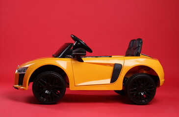 Child's electric toy car on red background