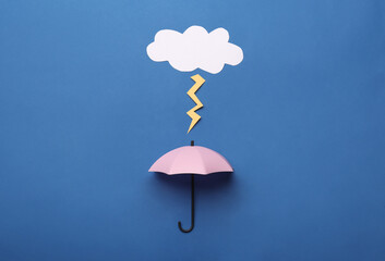 Mini umbrella and paper lighting cloud on blue background, flat lay - obrazy, fototapety, plakaty