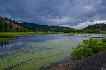 2021-06-14 COEUR D'ALENE RIVER WITH A BARN AND CLOUDY SKYS OUTSIDE OF HARRISON IDAHO