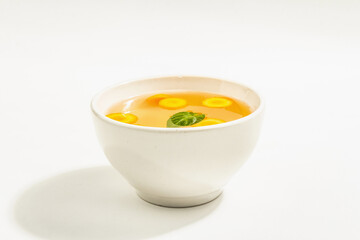 Transparent chicken broth with vegetables in ceramic bowls