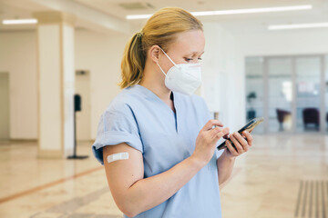 Austria, Vienna, Nurse in face mask using smart phone