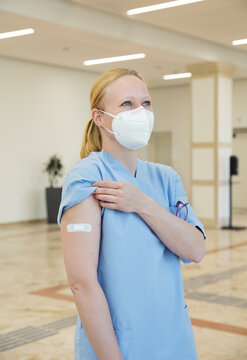 Austria, Vienna, Nurse in face mask with adhesive bandage on arm
