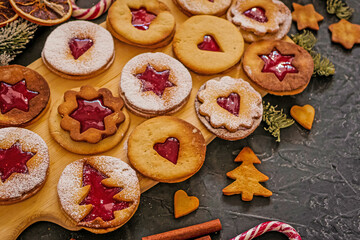 Homemade Christmas cookies with raspberry jam. Traditional Linzer cookies on a dark table, copy space