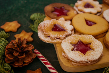Homemade Christmas cookies with raspberry jam. Traditional Linzer cookies on a dark table, copy space