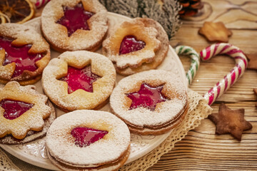 Delicious homemade Christmas cookies with jam, copy space. Traditional Linzer cookies on a dark table, copy space