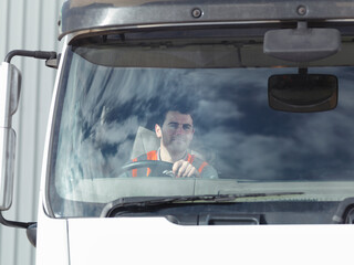 UK, Smiling truck driver in truck cabin