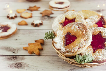 Delicious homemade Christmas cookies with jam, copy space. Traditional Linzer cookies on a dark table, copy space