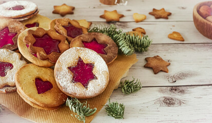 Obraz na płótnie Canvas Delicious homemade Christmas cookies with jam, copy space. Traditional Linzer cookies on a dark table, copy space