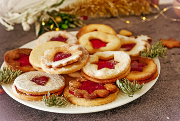 Delicious homemade Christmas cookies with jam, copy space. Traditional Linzer cookies on a dark table, copy space