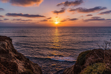 Vibrant sunset over the Pacific Ocean from the cliffs of a beach in San Diego California