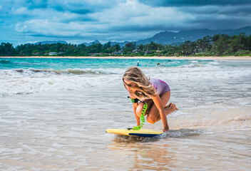 Girl Jumping on Body Board at the Beach