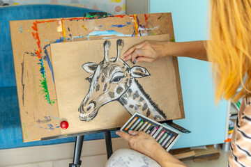 Artist female drawing pastel at home.