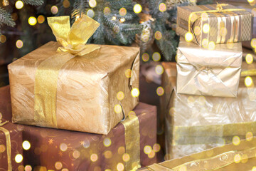 New Year's gift under the Christmas tree, New Year's box in gold color close-up.