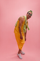 Full-length, active young afro man crosses legs in dynamic pose with copy space. Long sleeved hoodie tied at shoulders, bright wide smile creates pleasant atmosphere. Emotions and states mind, concept