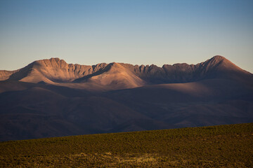Crown shaped dry mountains at late afternoon with last sunrays in Puna Argentina, near Yavi town. North Argentina
