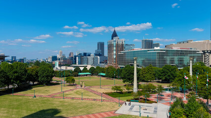 a stunning shot of the skyscrapers in downtown Atlanta and Centennial Olympic Park with lush green...