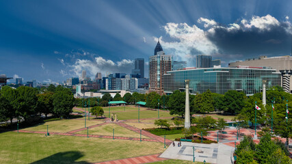 a stunning shot of the skyscrapers in downtown Atlanta and Centennial Olympic Park with lush green...