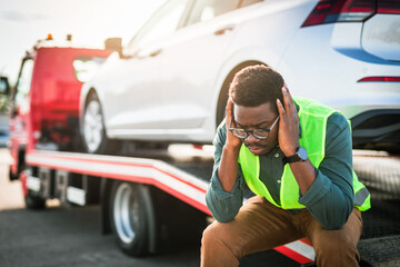 African American man using towing service for help car accident on the road. Roadside assistance...
